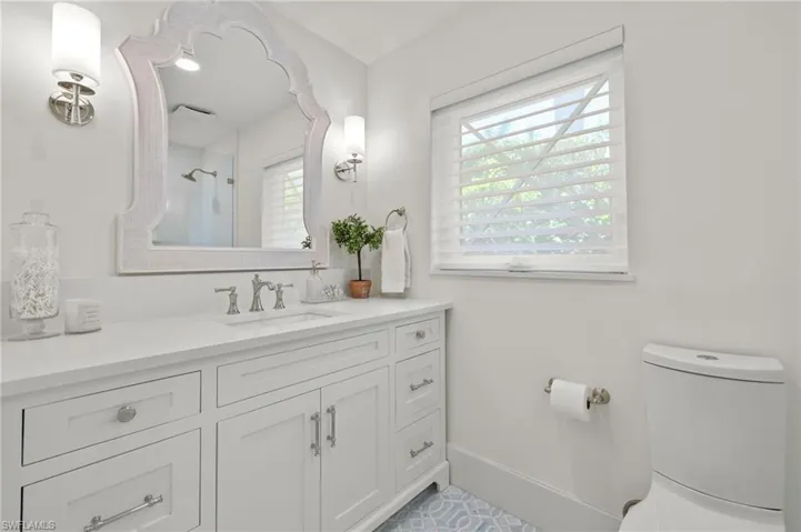 Bathroom featuring tile floors, vanity, and toilet