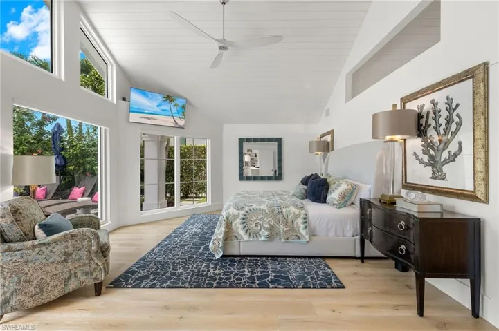 Bedroom with high vaulted ceiling, ceiling fan, and light wood-type flooring