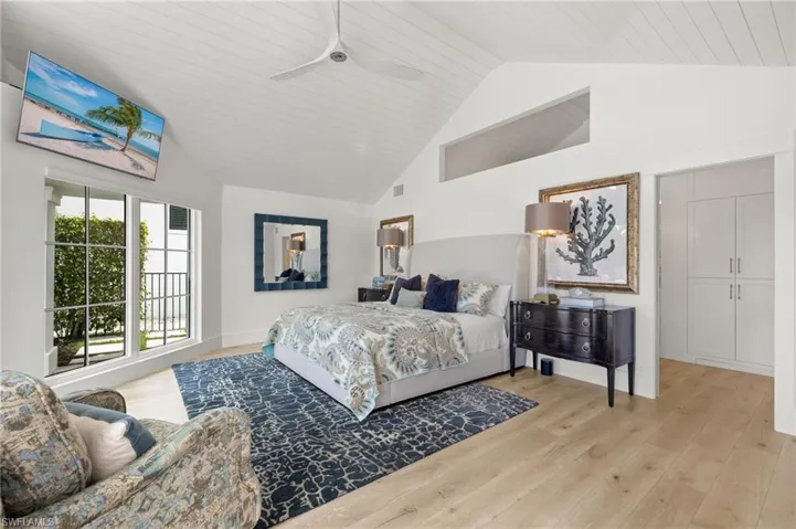 Bedroom featuring high vaulted ceiling, wood-type flooring, and ceiling fan