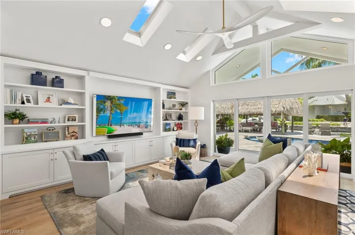 Living room featuring plenty of natural light, ceiling fan, light hardwood / wood-style floors, and a skylight