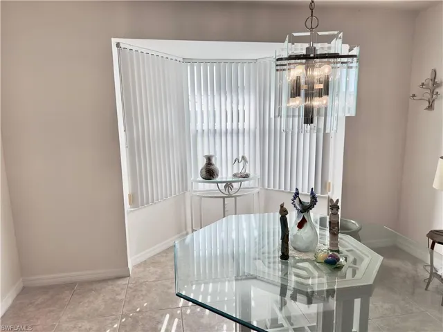 Tiled dining space with healthy amount of natural light and a chandelier