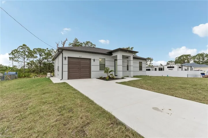 View of front facade featuring a front yard and a garage