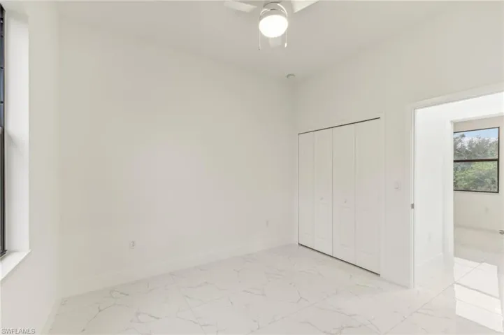 Unfurnished bedroom with ceiling fan and a closet