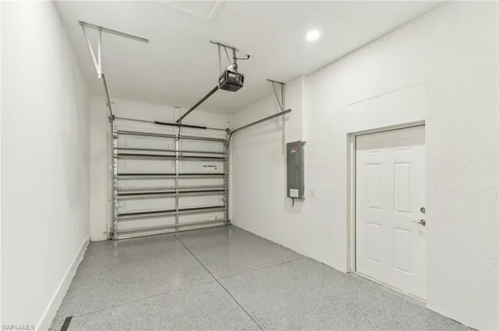 Garage featuring electric panel and a garage door opener