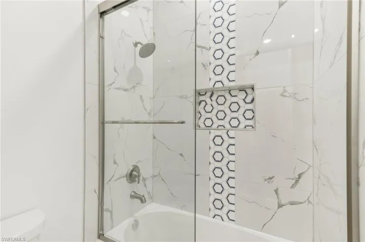 Bathroom with toilet and tiled shower / bath
