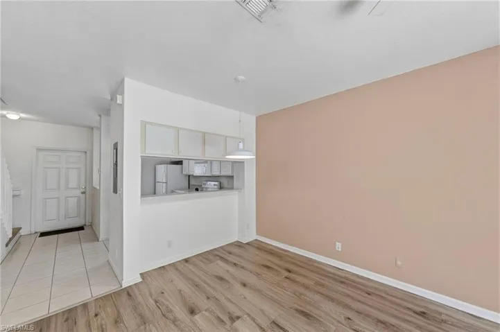 Unfurnished living room featuring light wood-style flooring and baseboards