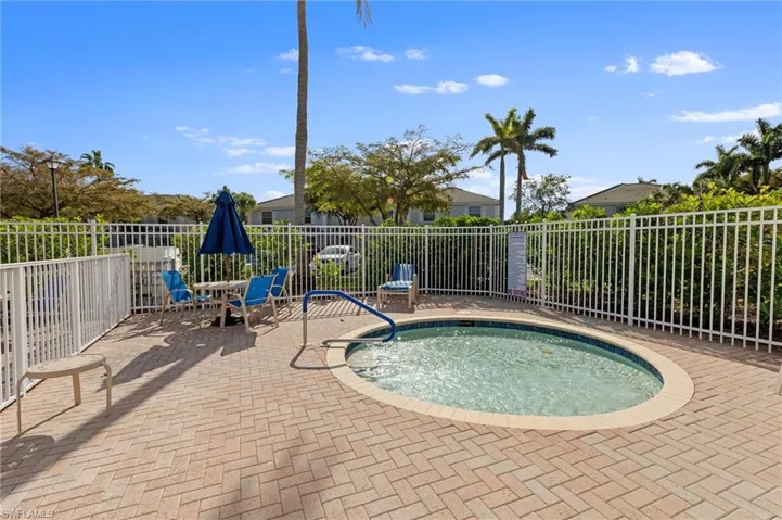 View of swimming pool featuring a community hot tub, a fenced backyard, patio surround, and outdoor dining space