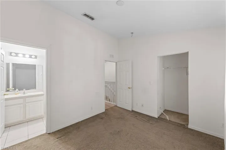 Unfurnished bedroom with carpet floors, a closet, and connected bathroom