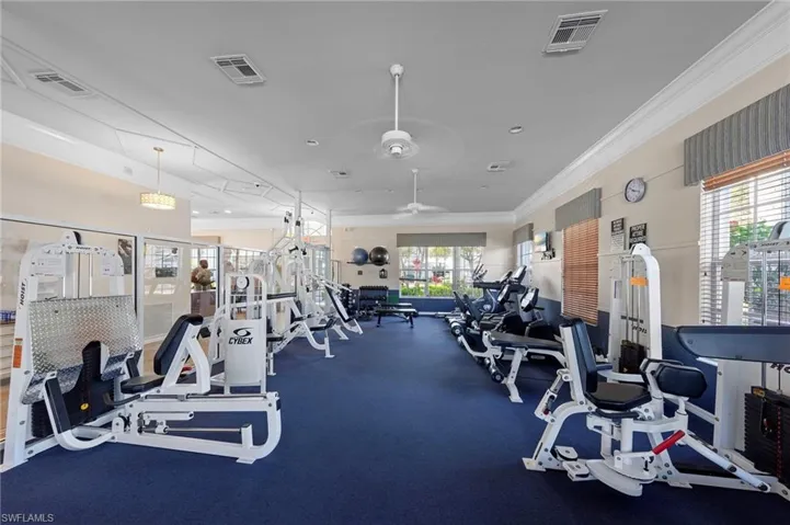 Gym with ornamental molding and ceiling fan
