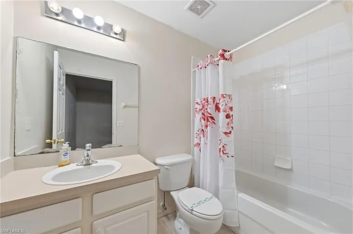 Bathroom with vanity and shower / tub combo with curtain