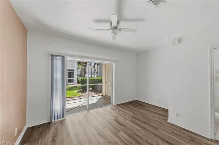 Empty room with ceiling fan, light wood-type flooring, a textured ceiling, and a textured wall