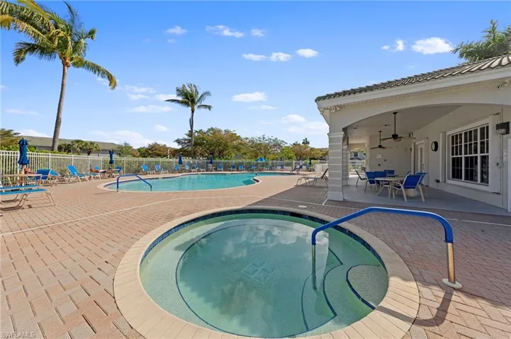 Community pool featuring a patio area, a community hot tub, and outdoor dining space