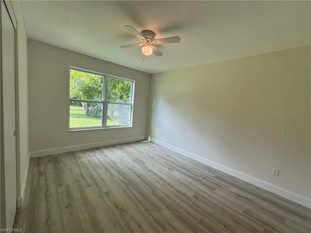 Empty room with light wood-style floors and ceiling fan