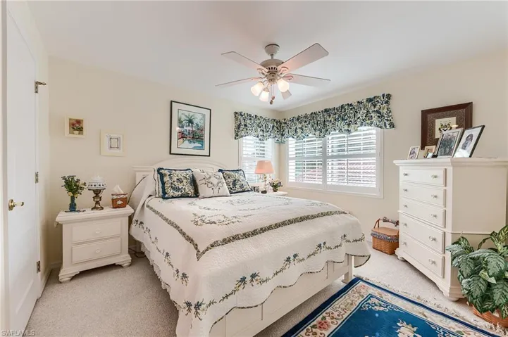 Bedroom featuring a ceiling fan and light colored carpet