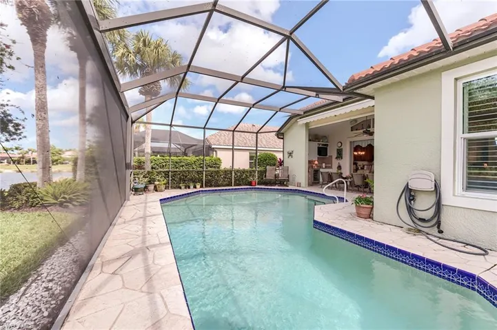Pool featuring a patio area, ceiling fan, and glass enclosure