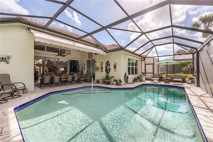 Outdoor pool featuring a patio area, glass enclosure, and a ceiling fan