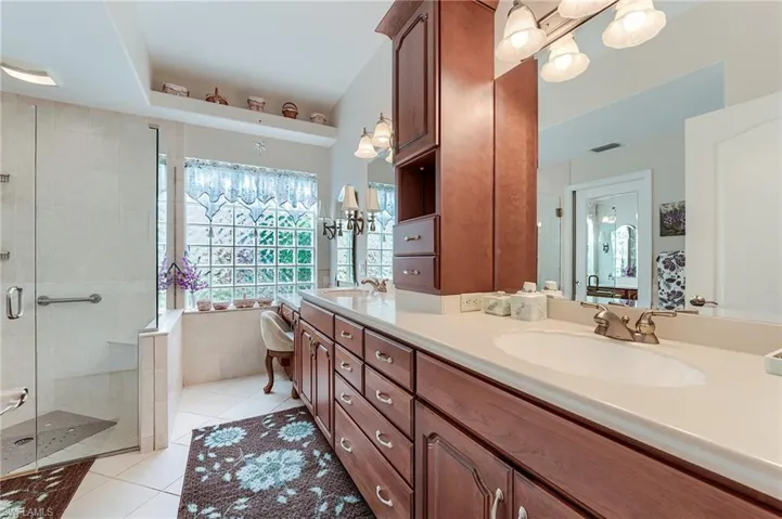 Bathroom with a stall shower, visible vents, a chandelier, a sink, and tile patterned floors