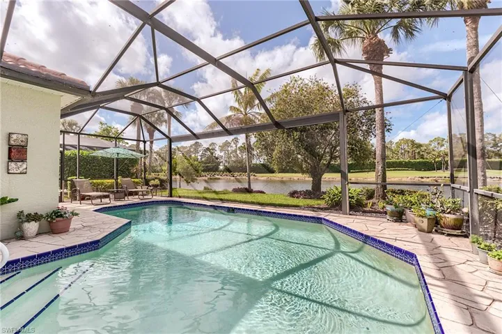 Outdoor pool featuring a lanai, a patio area, and a water view