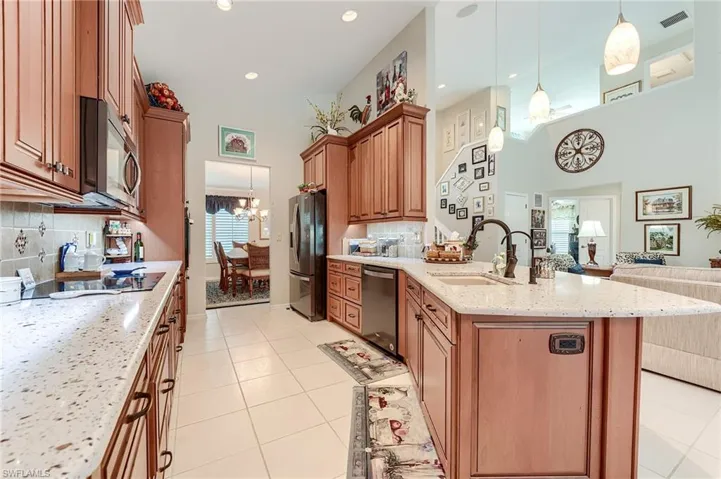 Kitchen with an inviting chandelier, open floor plan, visible vents, appliances with stainless steel finishes, and a sink