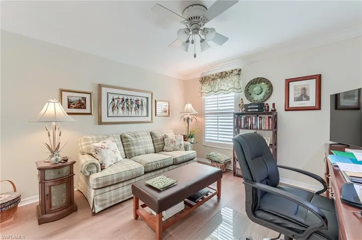 Home office featuring light wood-style flooring, baseboards, a ceiling fan, and crown molding