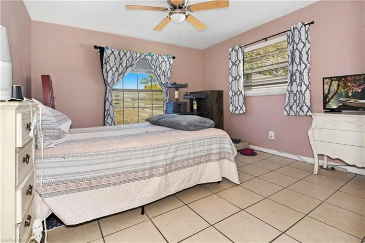 Bedroom with ceiling fan and light tile patterned floors