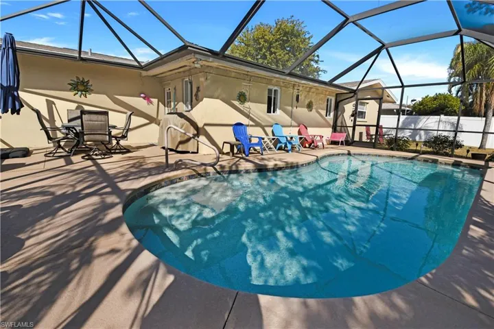 View of pool featuring a sunroom, glass enclosure, and patio surround