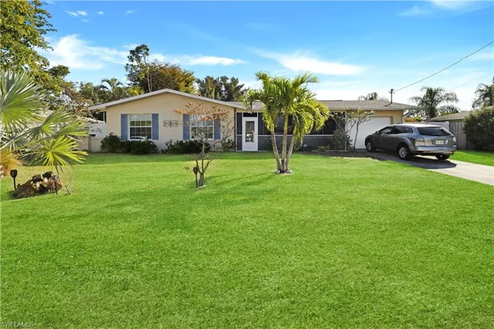 Ranch-style house featuring a front lawn, concrete driveway, and an attached garage