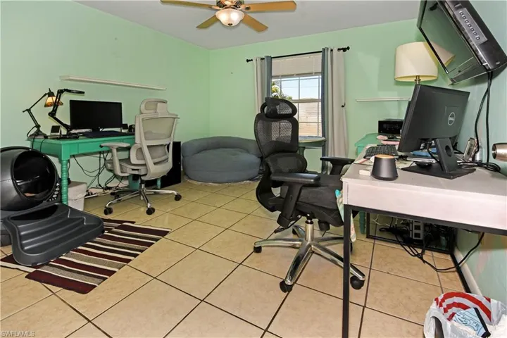 Office area with light tile patterned floors and ceiling fan