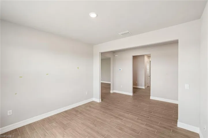 Spare room featuring baseboards and light wood-style flooring