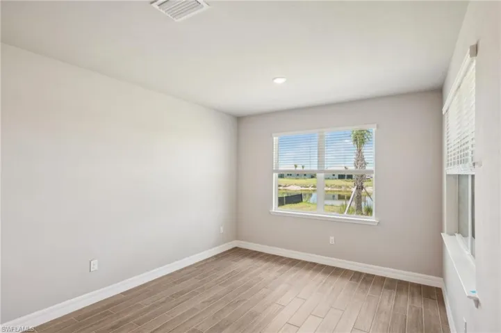 Spare room featuring wood finished floors, baseboards, and recessed lighting