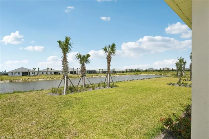 View of green lawn with a water view and a residential view