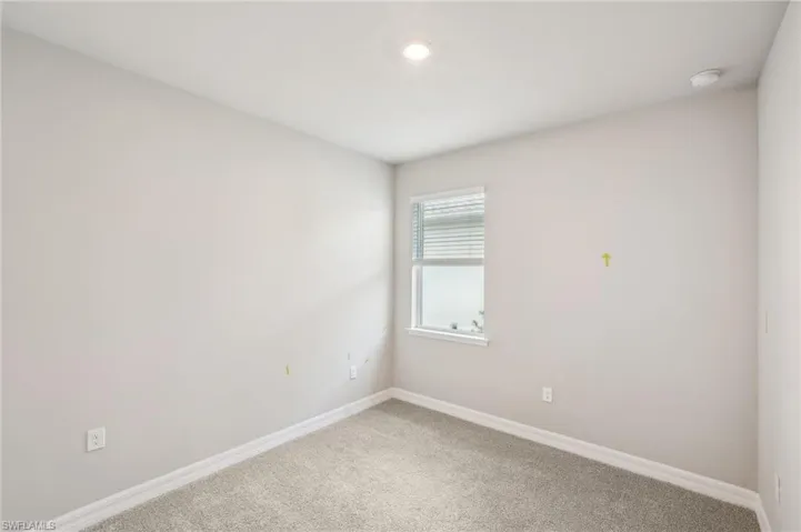 Unfurnished room featuring baseboards, carpet, and a smoke detector