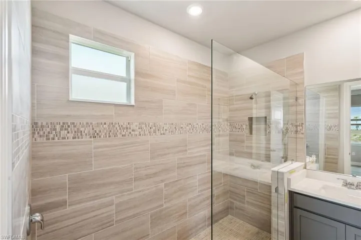 Full bathroom featuring a stall shower, vanity, and healthy amount of natural light