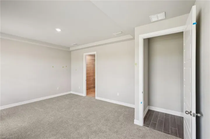 Unfurnished bedroom featuring baseboards, dark carpet, and recessed lighting