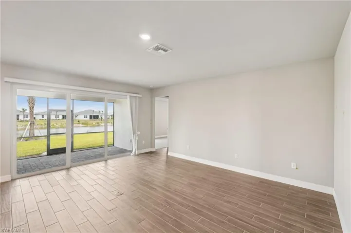Spare room with baseboards, wood finished floors, recessed lighting, and a water view