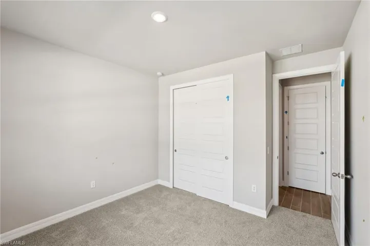 Unfurnished bedroom featuring carpet floors, baseboards, a closet, and recessed lighting