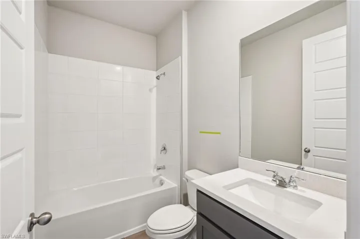 Full bath with toilet, vanity, and shower / bath combination