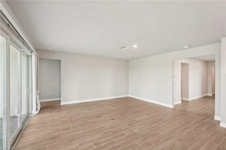 Unfurnished room with baseboards, light wood-style flooring, and recessed lighting