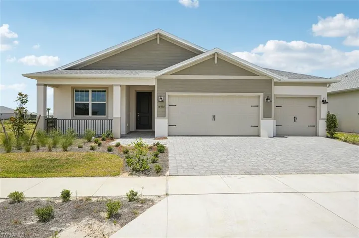 View of front facade with decorative driveway, covered porch, an attached garage, stucco siding, and roof with shingles