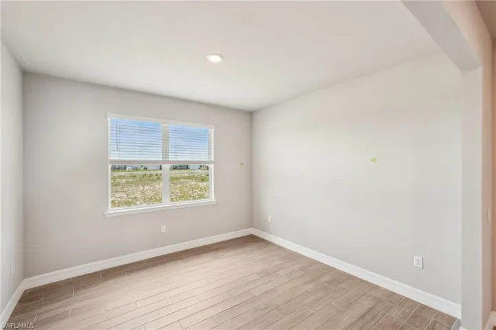 Unfurnished room featuring light wood-type flooring and baseboards