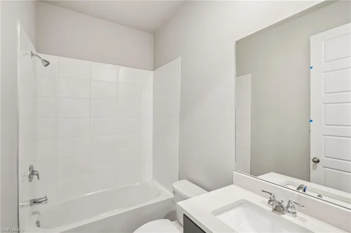 Full bath featuring toilet, vanity, and shower / tub combination