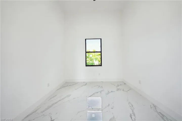 Unfurnished room with light marble finish floors and baseboards