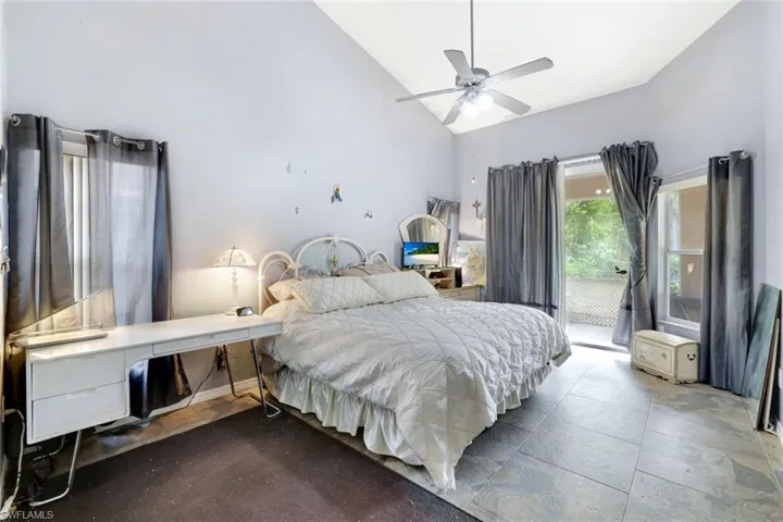 Bedroom with access to exterior, high vaulted ceiling, and a ceiling fan