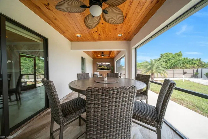 Screened outdoor patio featuring a wood-finish plank ceiling with an integrated ceiling fan and recessed lighting