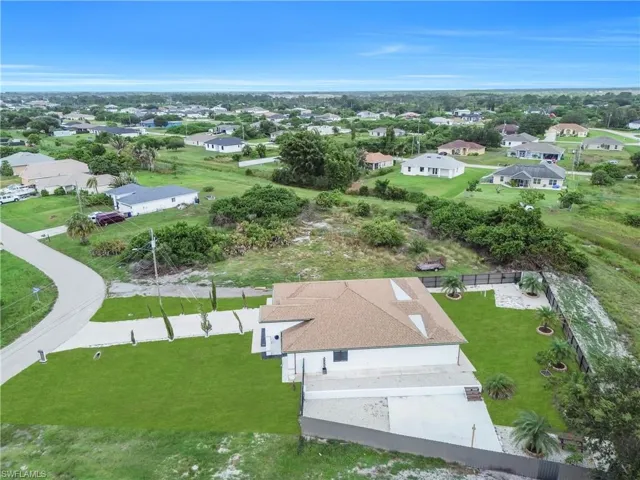 Contemporary single-story residence featuring a neutral exterior, a brown shingle roof, and a meticulously landscaped front and side yard