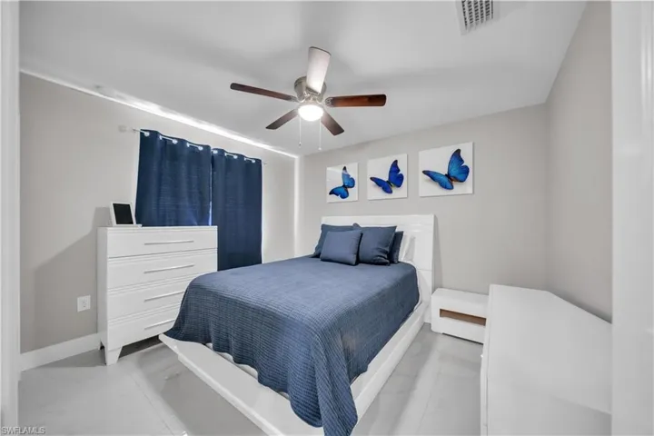 Bedroom featuring light gray walls, a ceiling fan with integrated lighting, and light-colored flooring