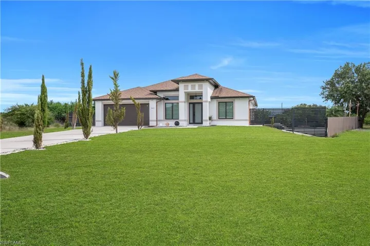 Contemporary single-story residence featuring a white stucco exterior and a brown shingle roof