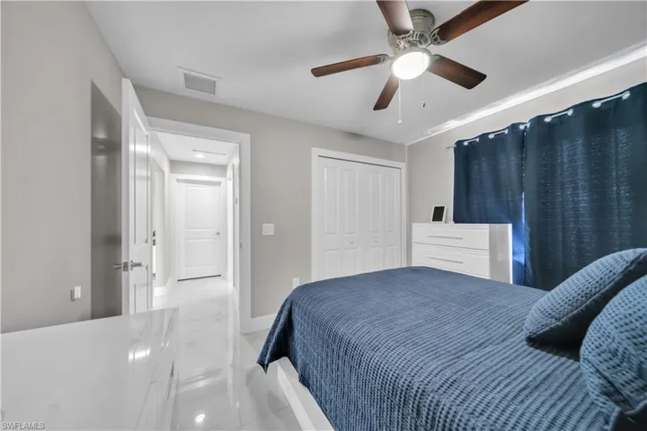 Bedroom featuring a ceiling fan with integrated lighting, white bifold closet doors, and light-toned walls