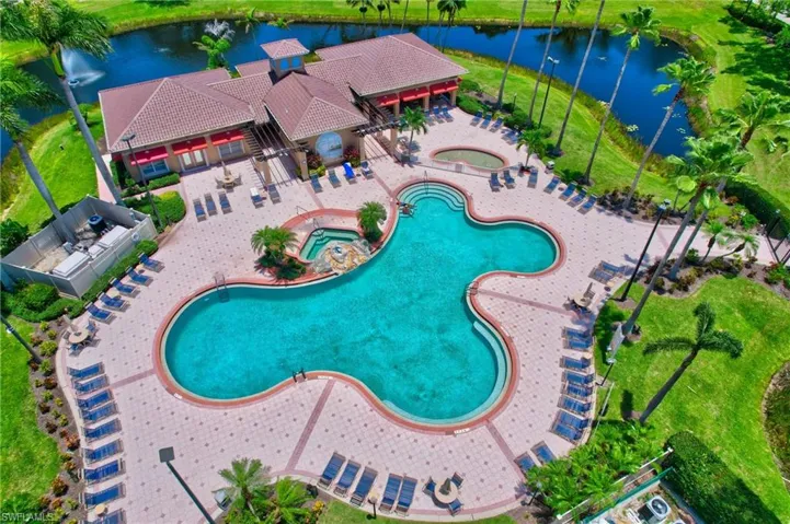 Community pool featuring a hot tub, a water view, and a patio