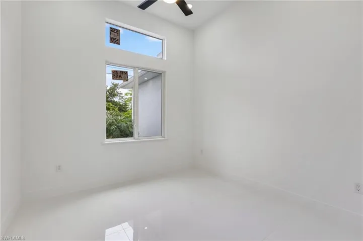 Tiled spare room with baseboards and a ceiling fan